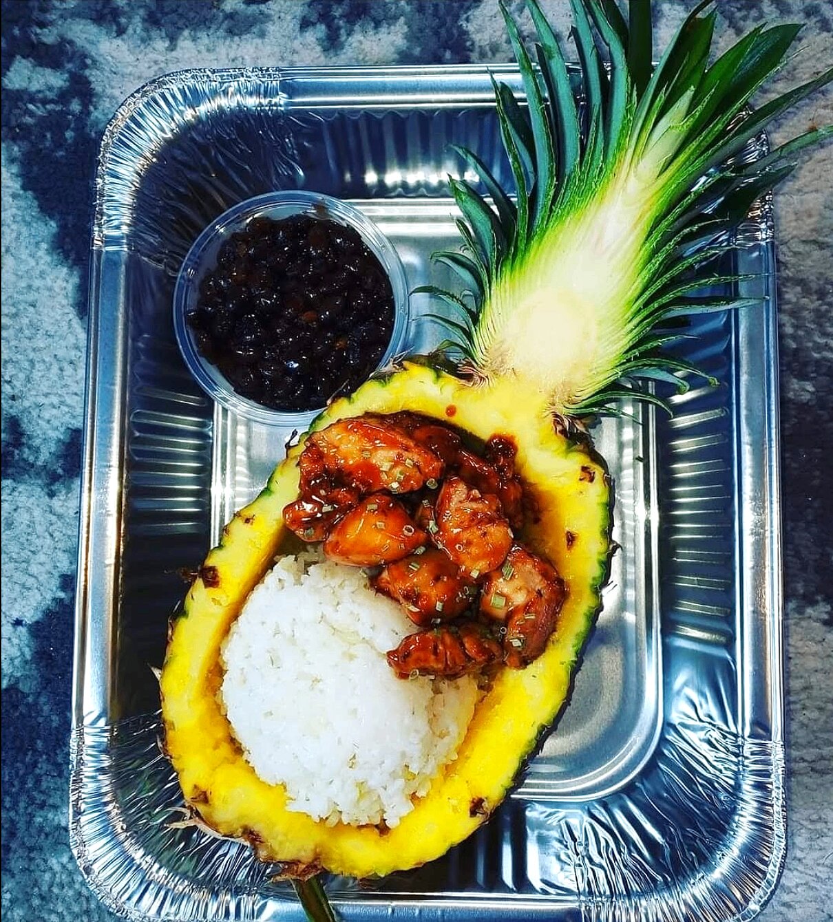 Teriyaki chicken served in a pineapple bowl